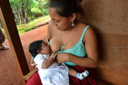 Mujer que recibe información sobre la importancia de la lactancia materna en El Estor, Izabal